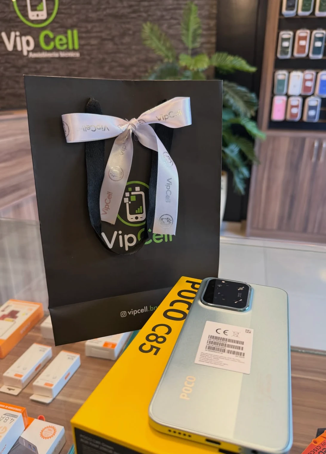 POCO C85 na caixa ao lado da sacola Vip Cell
